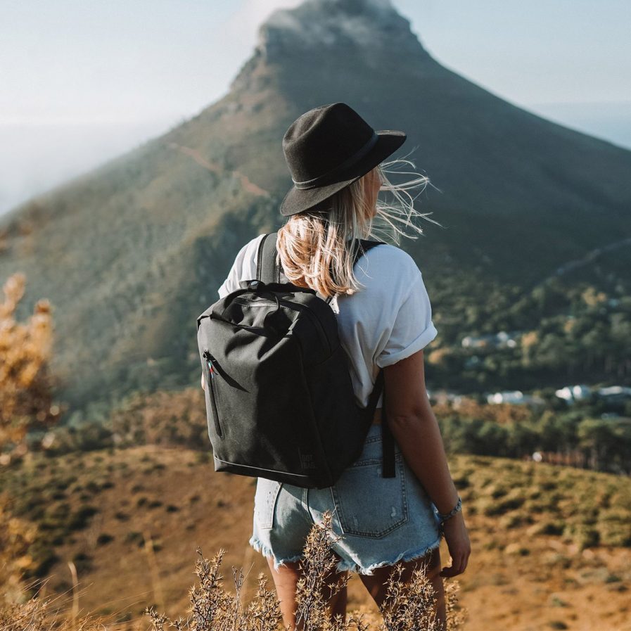 Frau mit Hut und schwarzem Rucksack