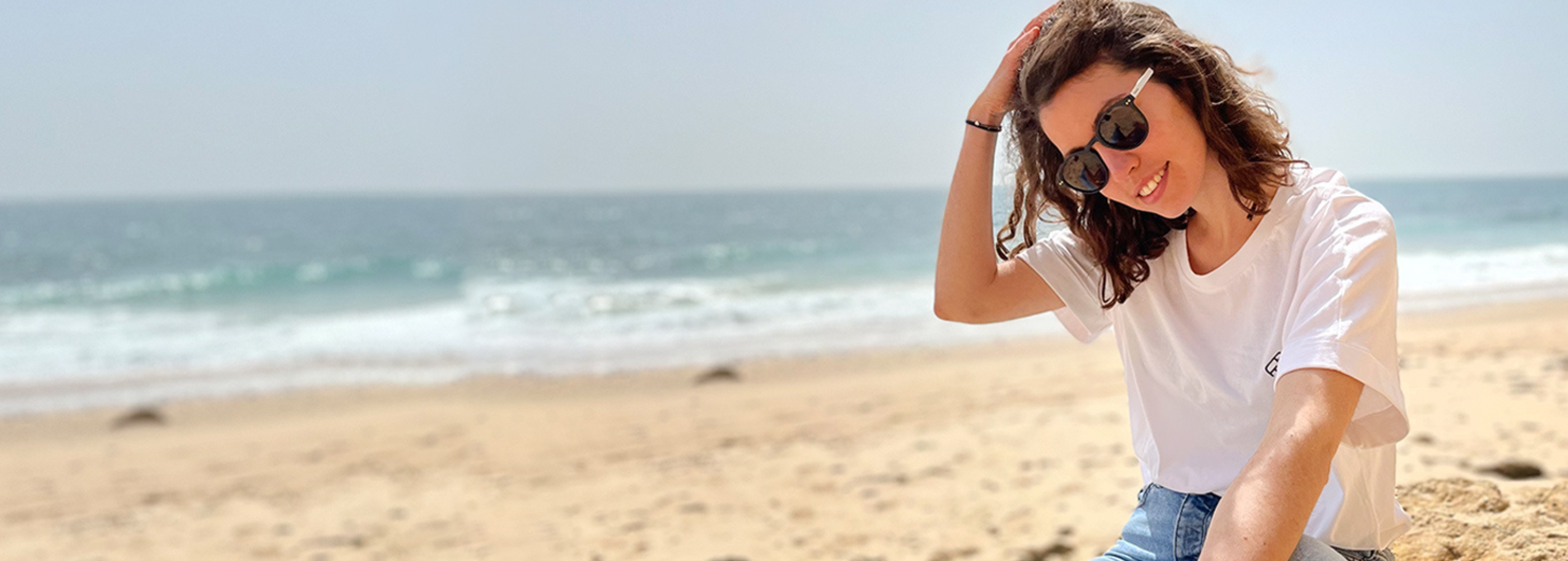 Frau am Strand mit weißem Shirt